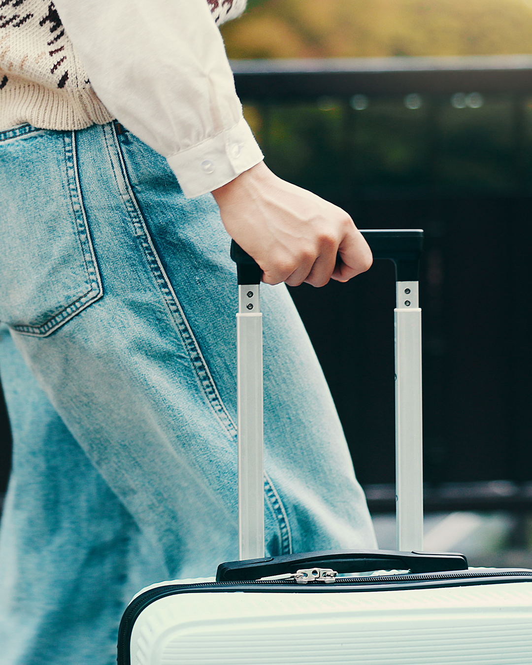 Person mit der Hand am Koffergriff