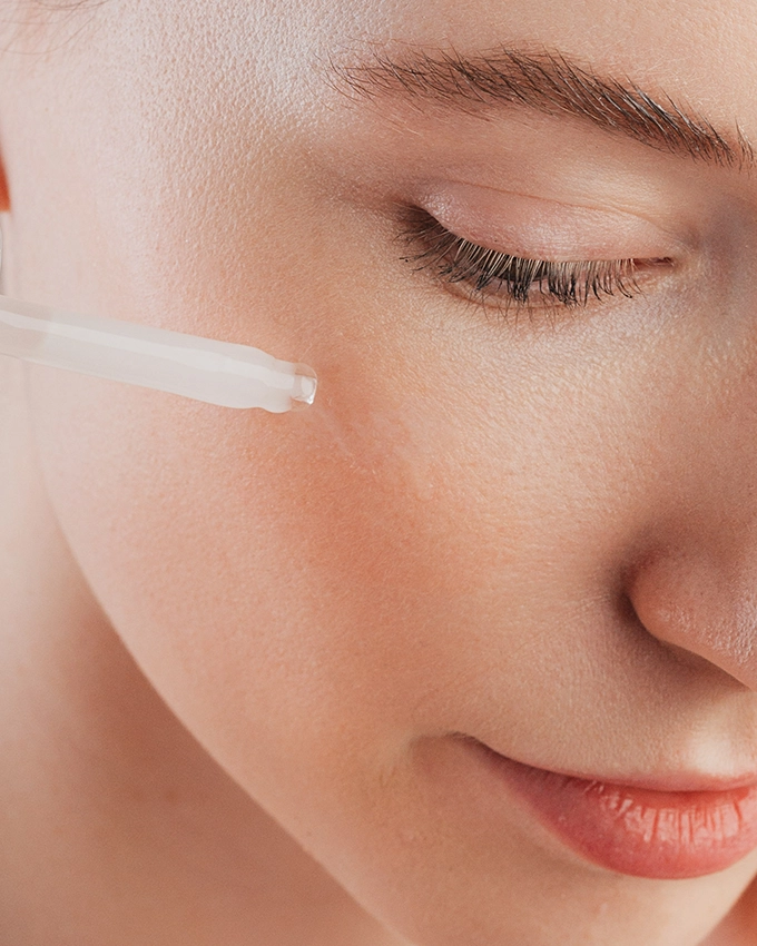 Serum is applied to the woman's cheek with a pipette
