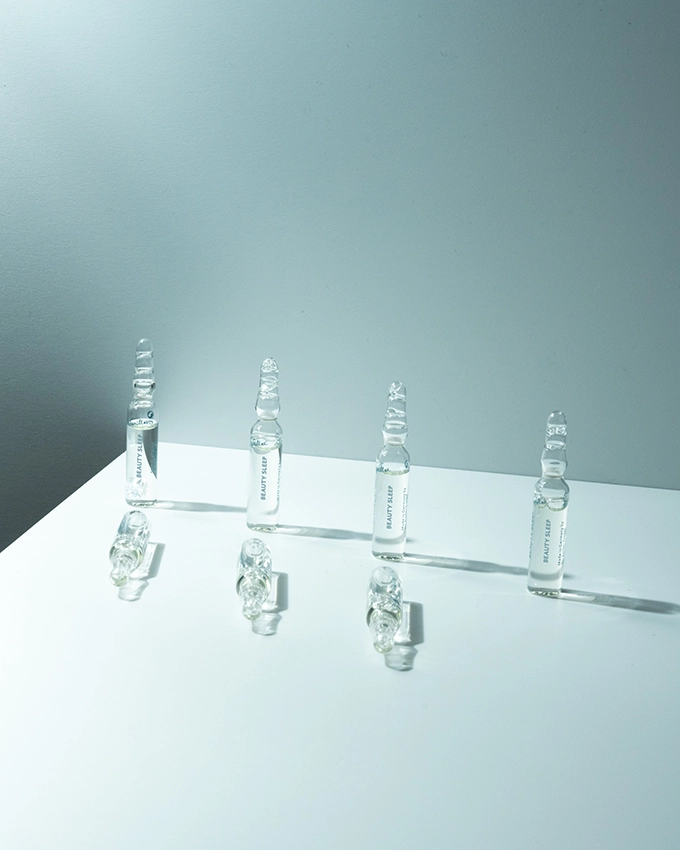 Several ampoules stand on a table with a bluish background