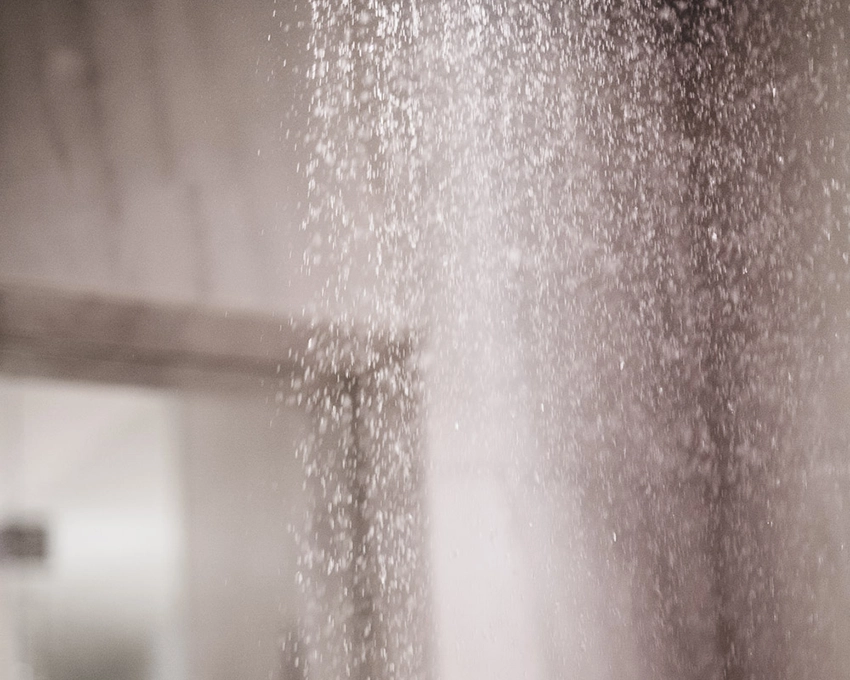 Feiner Wasserstrahl vor glatter Wand im Spa