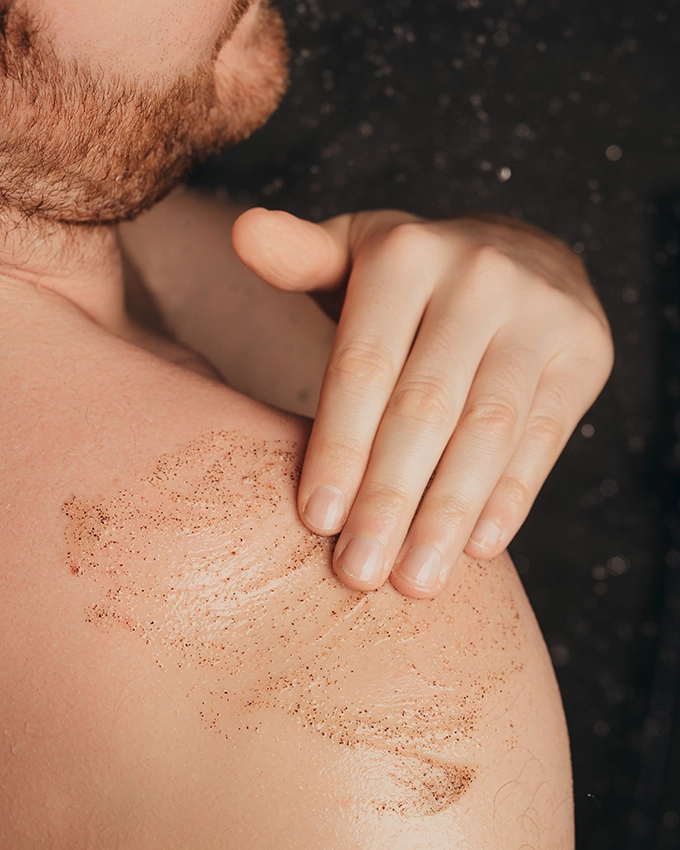 Mann reibt das Gentle Face & Body Peeling Gel auf die Schulter