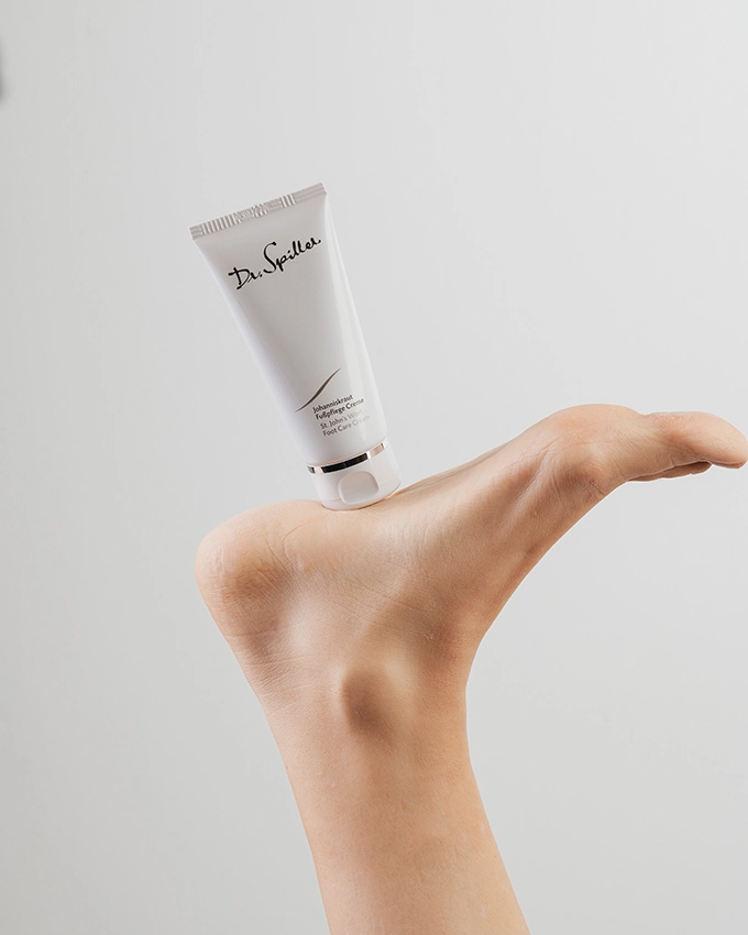 Johanniskraut Fußpflege Creme steht auf dem Fuß