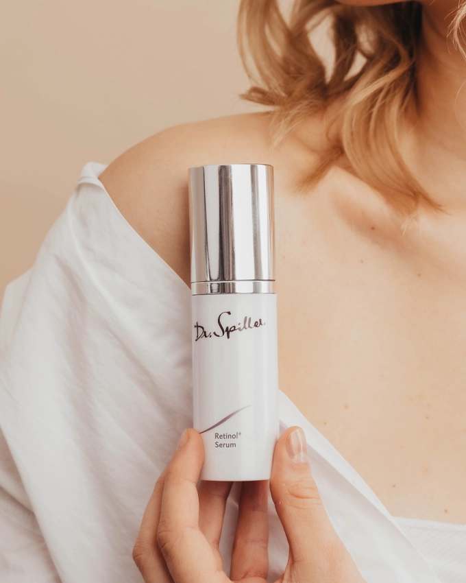 Retinol Serum Flasche wird vor der Schulter gehalten