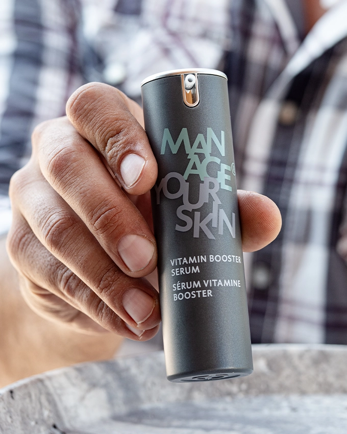 Mann hält das Vitamin Booster Serum in der Hand