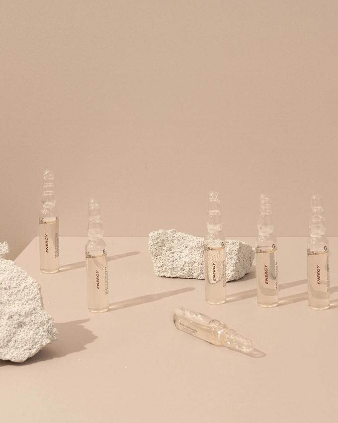 Mehrere Ampullen stehen auf einem Tisch mit rosafarbenen Hintergrund