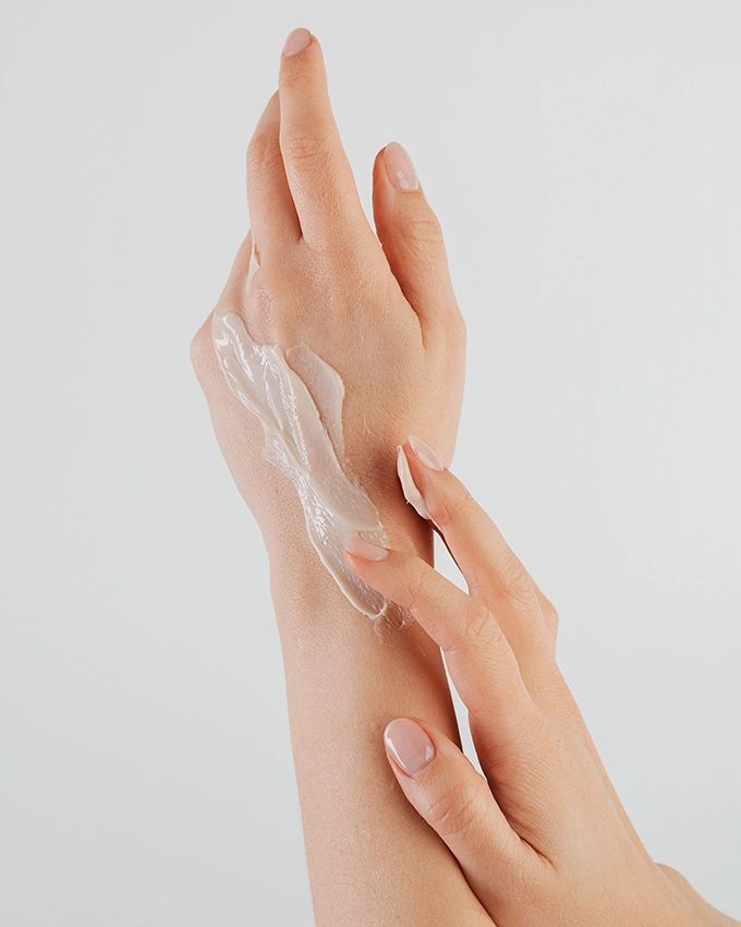 Frau pflegt sich die Hände mit der Hand Cream