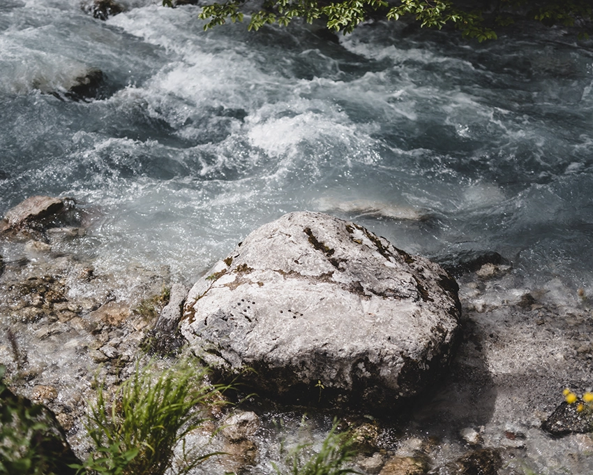 Large stone by a wild mountain stream with bubbling water