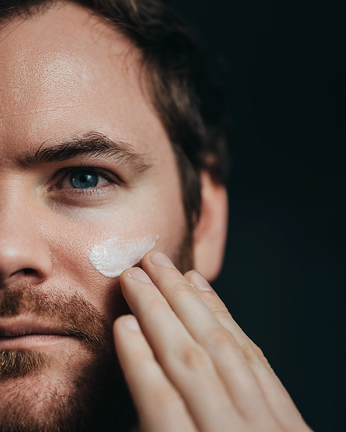 Mann trägt Activating Age Repair Complex auf das Gesicht auf