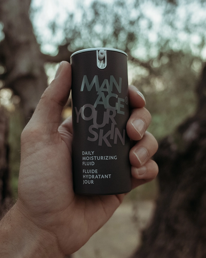 Daily Moisturizing Fluid wird in die Luft gehalten in der Natur