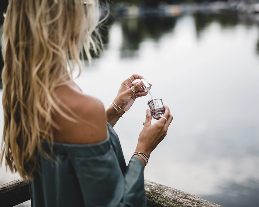 Woman applying Dr. Spiller skin care product outdoors