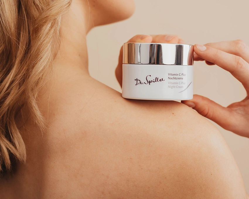 Frau hält Dr. Spiller Pflegecreme in der Hand auf Schulterhöhe