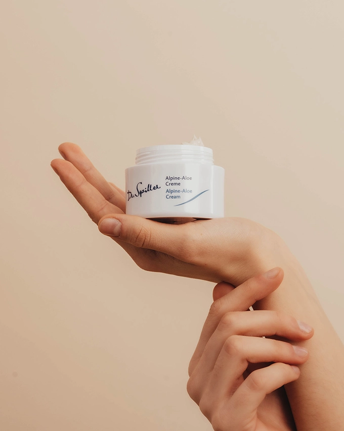 Frau hält Alpine Aloe Gesichtscreme in der Hand